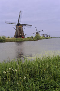 Traditional windmill on field against sky