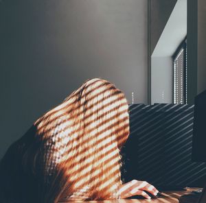 Woman with obscured face working on computer