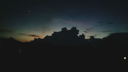 Silhouette trees against sky at night