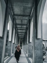 Rear view of man walking in tunnel