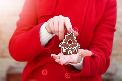 Midsection of woman holding gingerbread cookie during christmas