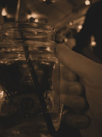 Midsection of person holding ice cream in jar