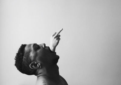 Portrait of man smoking cigarette against white background