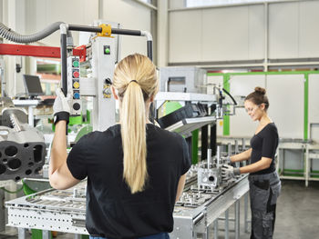 Two women working on a machine