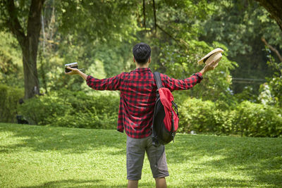 Rear view of man standing on mobile phone