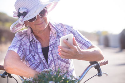 Smiling woman on bicycle using mobile phone