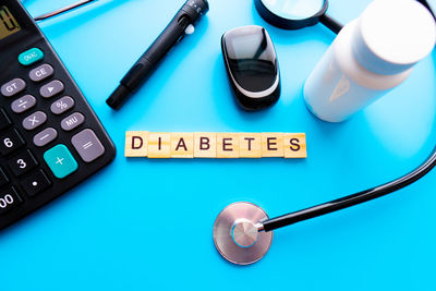High angle view of computer keyboard on blue background