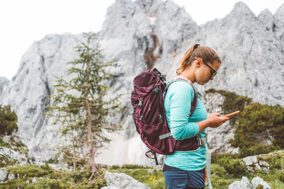 Side view of woman standing against mountain