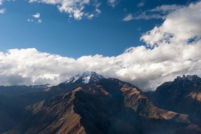 Scenic view of snowcapped mountains against cloudy sky