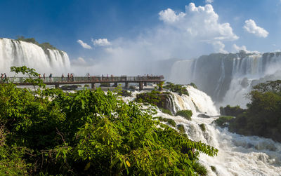 Panoramic view of waterfall against cloudy sky