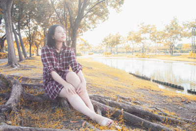 Portrait of woman sitting against trees