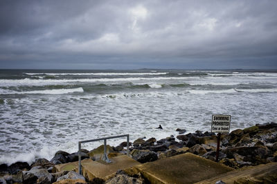 Lone surfer heads out into surf at strandhill beach, sligo, ireland where swimming is prohibited