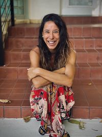 Portrait of a smiling young woman sitting outdoors