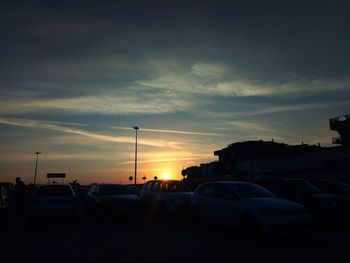 Cars on road against sky during sunset