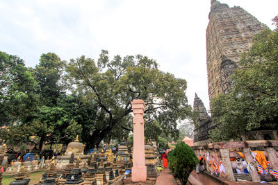 Group of people in temple by building against sky