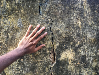 Person touching a cracked wall