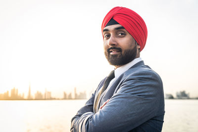 Portrait of businessman wearing turban standing by river