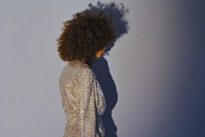 Side view of woman standing against snow