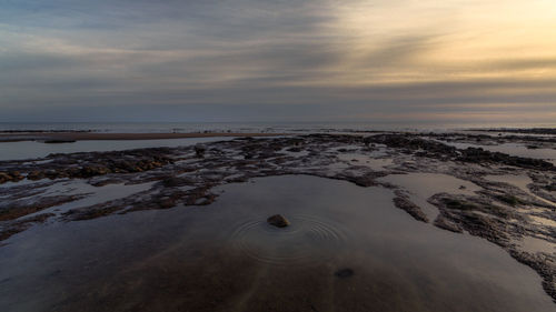 Scenic view of beach against sky during sunset