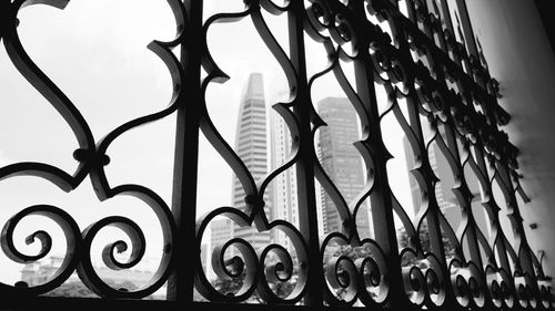 Low angle view of metal fence against sky