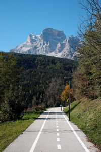 Road leading towards mountains against sky