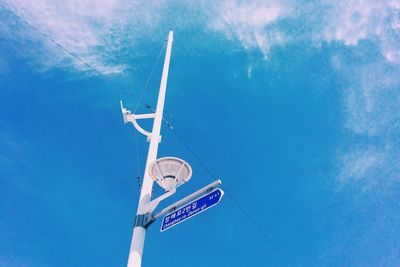 Low angle view of sign board against blue sky