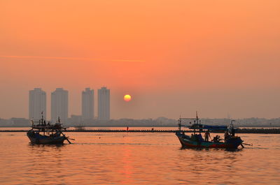 Boat sailing on sea against sky during sunset