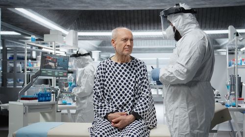Side view of young woman standing against building