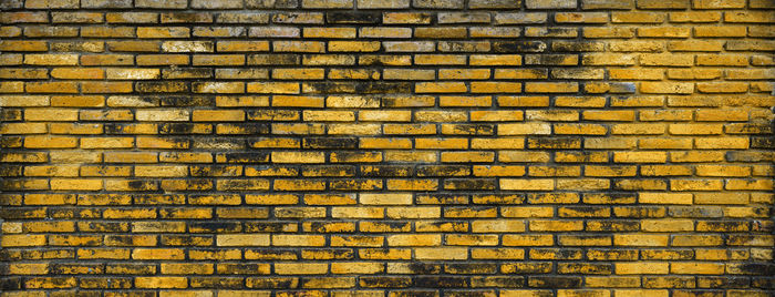 Old and dirty brick wall with yellow paint, yellow brick wall for blank background