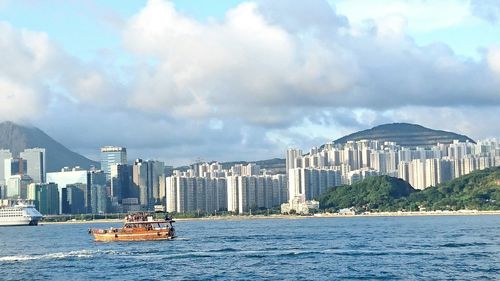 View of boats in sea against cityscape