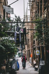 Rear view of people walking on street amidst buildings