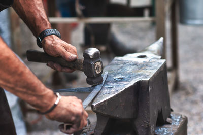 Midsection of man working on metal structure