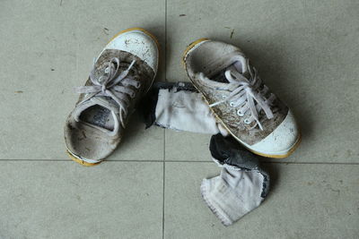High angle view of dirty shoes on tiled floor