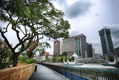 Bridge amidst buildings in city against sky