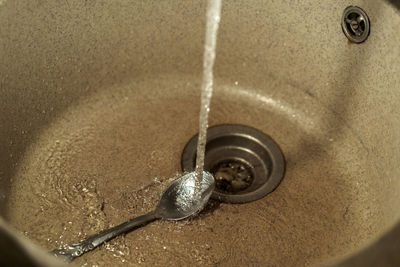 High angle view of water flowing from faucet at home