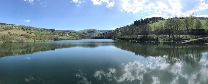 Scenic view of lake by trees against sky