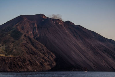 Scenic view of sea and mountains against clear sky