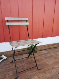 Empty chair on table against wall