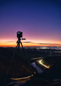 Silhouette of camera against sky at night