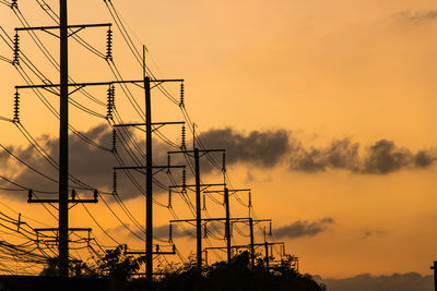 Low angle view of silhouette electricity pylon against sky during sunset