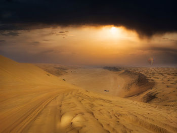 4wd tracks in the oman desert rub al khali in evening sun glow before a thunderstorm