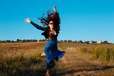 Full length of happy woman standing on field