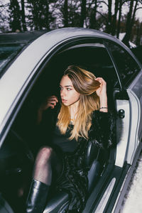 Young woman with long hair sitting in car