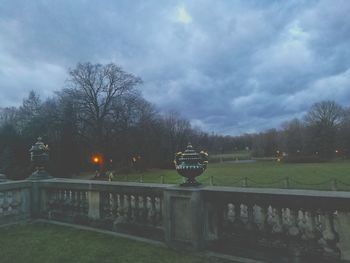 Railing by trees against sky