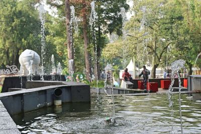 People in boat by lake against trees