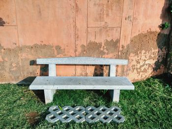 Empty bench against wall