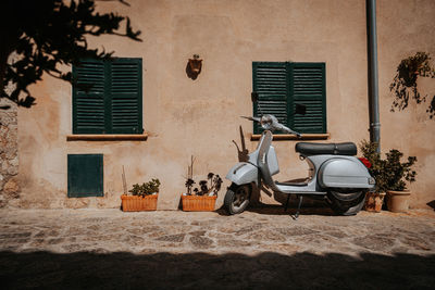 Motor scooter on wall against building