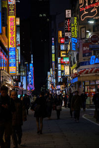 People walking on city street at night