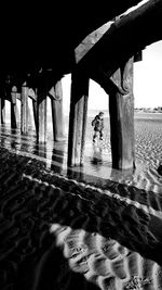 Silhouette bridge on beach against sky