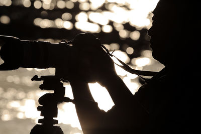 Close-up of silhouette man photographing with camera